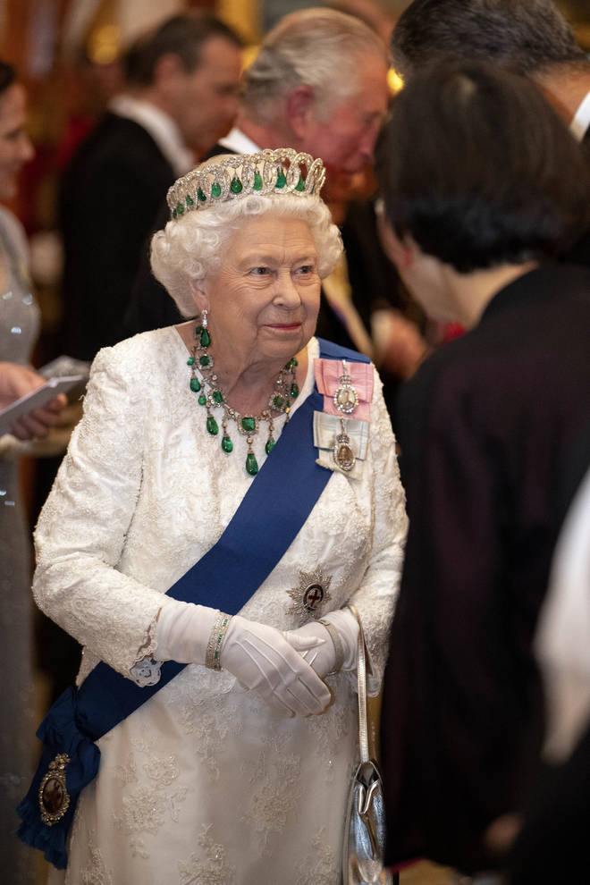 Queen Elizabeth II wore white, styled with a number of emerald jewels