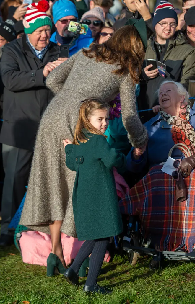 Princess Charlotte dressed in a green coat, matching her mum's hat