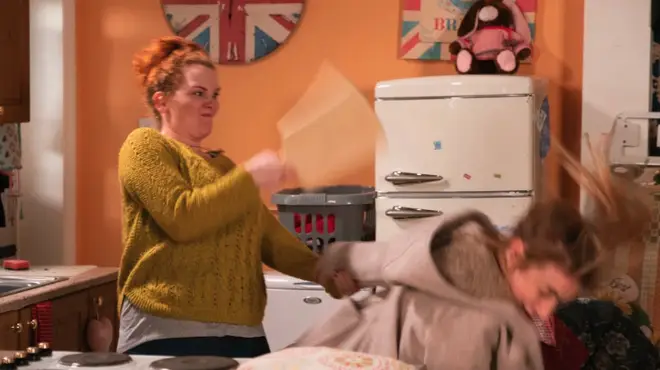 Fiz hits Jade over the head with a chopping board