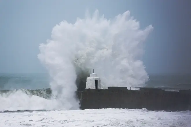 Waves pound against the harbour wall at Portreath, Cornwall.