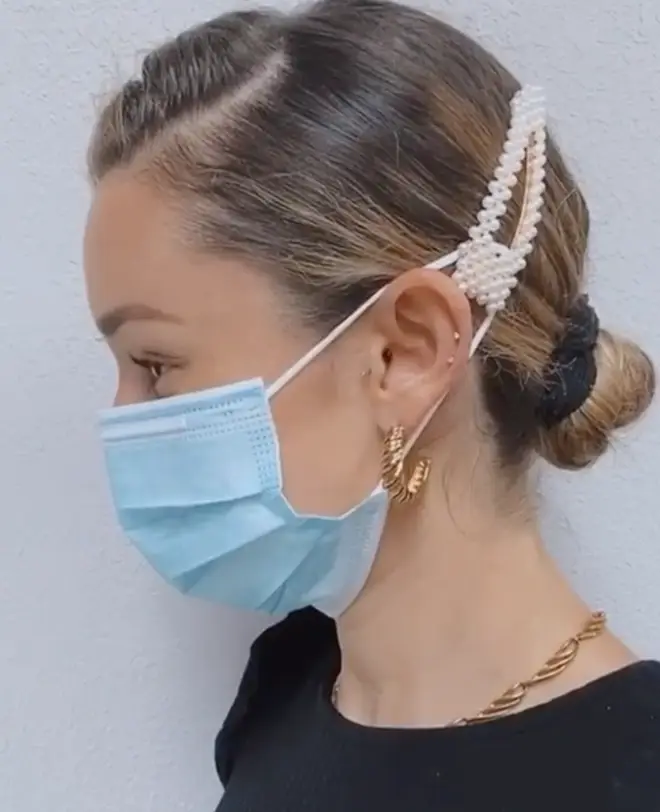 The hairdresser used a pearl clip to bring the mask strings back from the ears