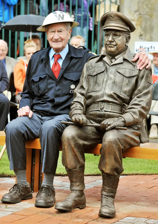 Bill Pertwee who starred in the classic TV comedy Dad's Army sits beside at bronze statue of Capatin Mainwaring played by actor Arthur Lowe.