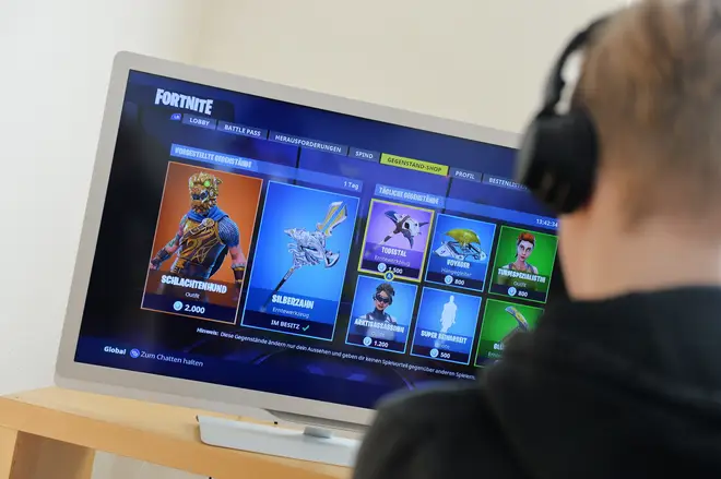 A boy plays Fortnite on his games console