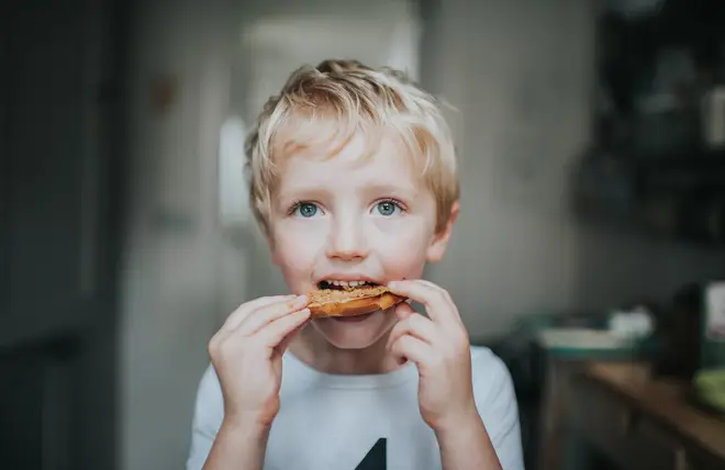 A child eating a peanut bagel