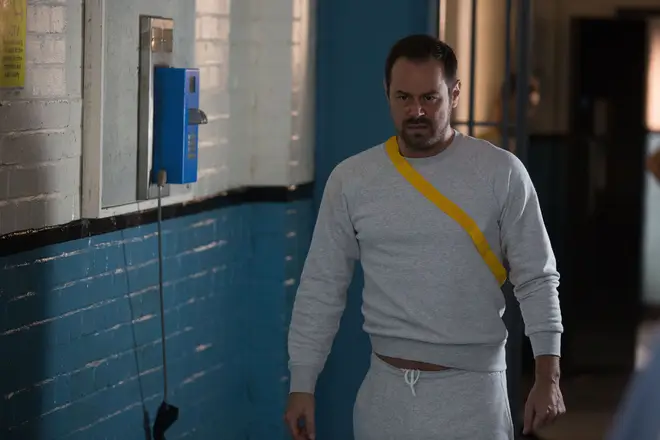 Mick Carter walks angrily through the prison in EastEnders