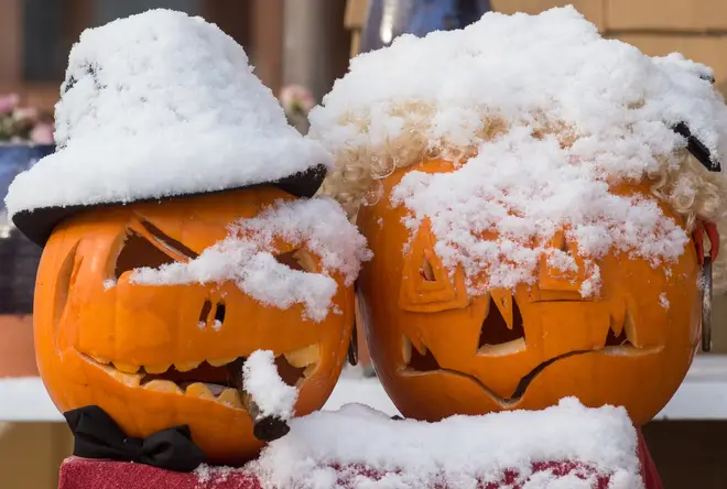 Two pumpkins covered in snow