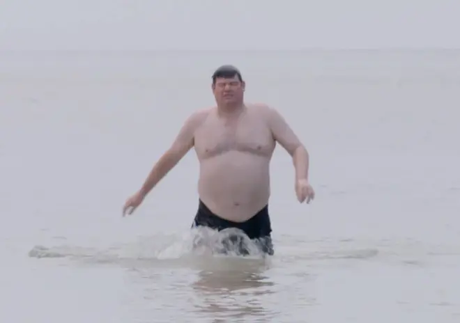 Mark Labbett is seen walking out the sea in the clip