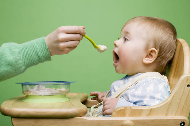Baby being fed food by an adult