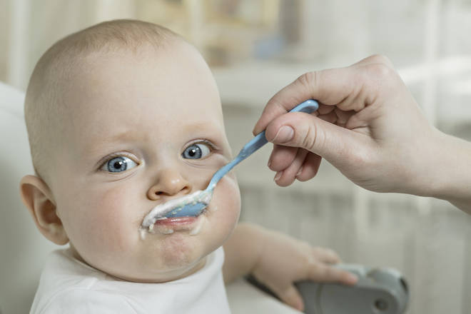 A baby has a mouthful of food