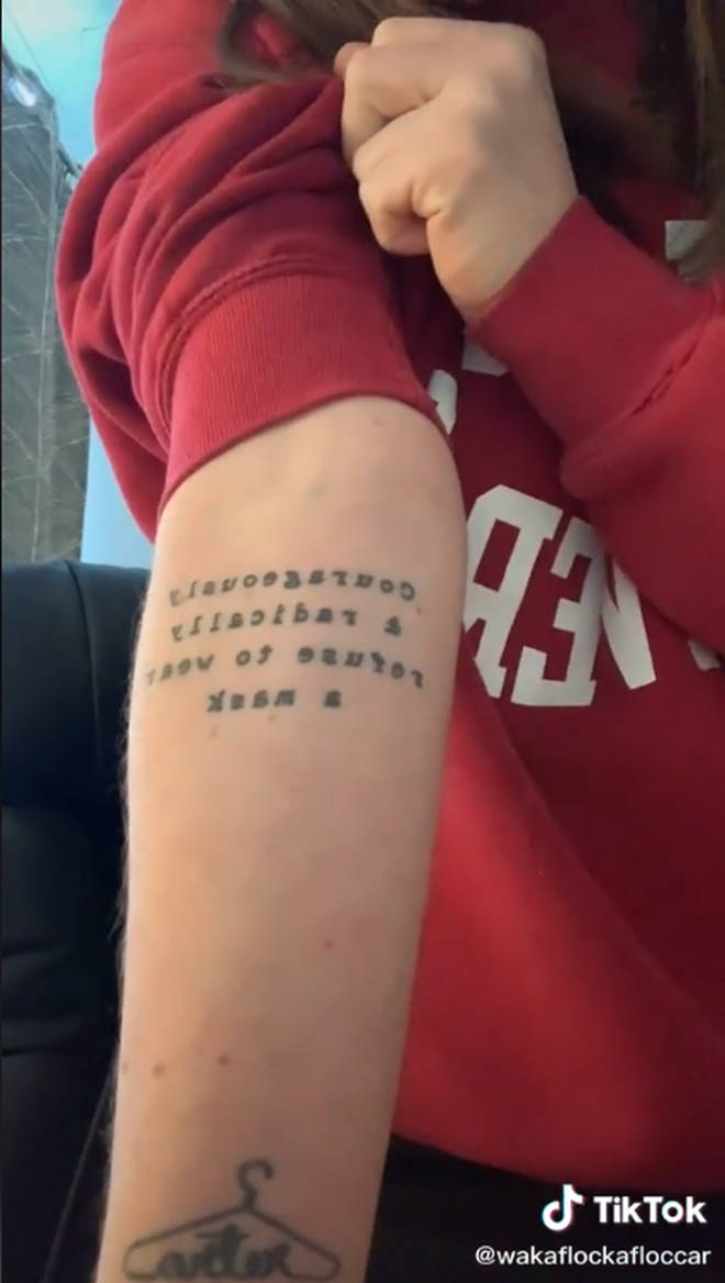 The tattoo reads: "Courageously and radically, refuse to wear a mask"