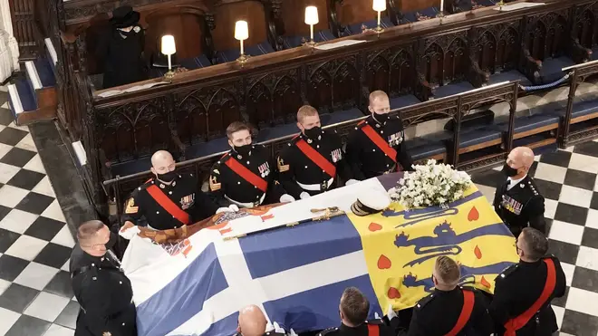 The Queen stands as the coffin is carried into the Chapel