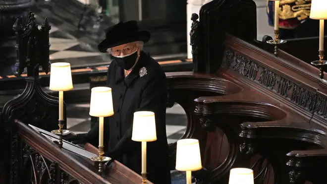 The Queen watches as Prince Philip's coffin enters St George's Chapel