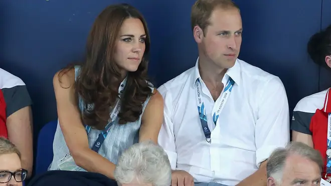Kate and William hold hands as they watch swimming together