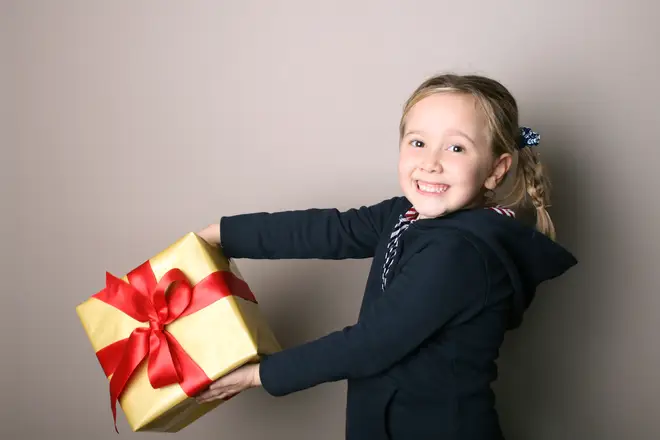 School child holding a Christmas present