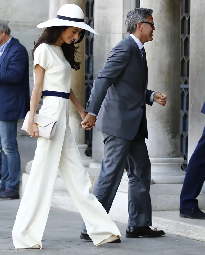 Amal and George Clooney hold hands on their way to their civil ceremony in Italy
