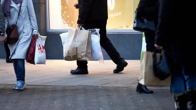 People carrying shopping bags from H&M and Primark on the high street