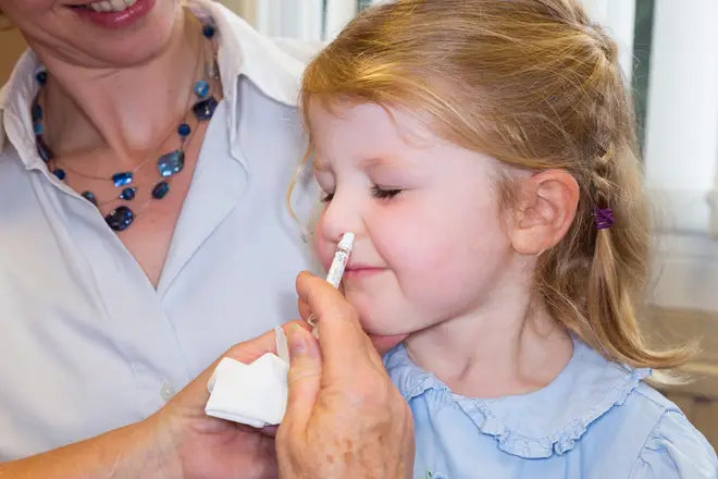 Children receive their flu vaccine via a nasal spray