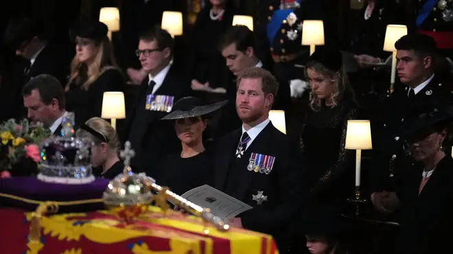 Prince Harry and Meghan Markle look upon the Queen's coffin during the state funeral at Westminster Abbey