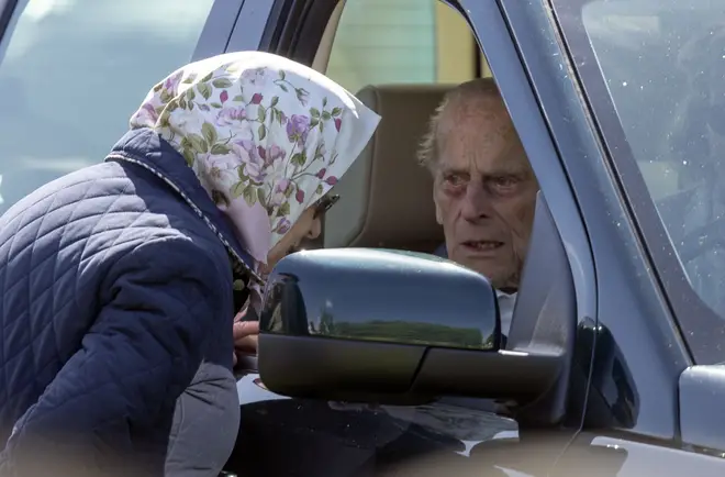 Prince Philip pictured in his Land Rover speaking to the Queen