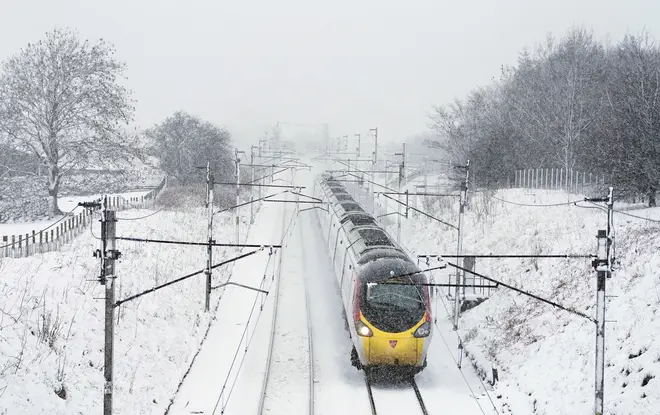 A Virgin Train makes its way through snow towards London