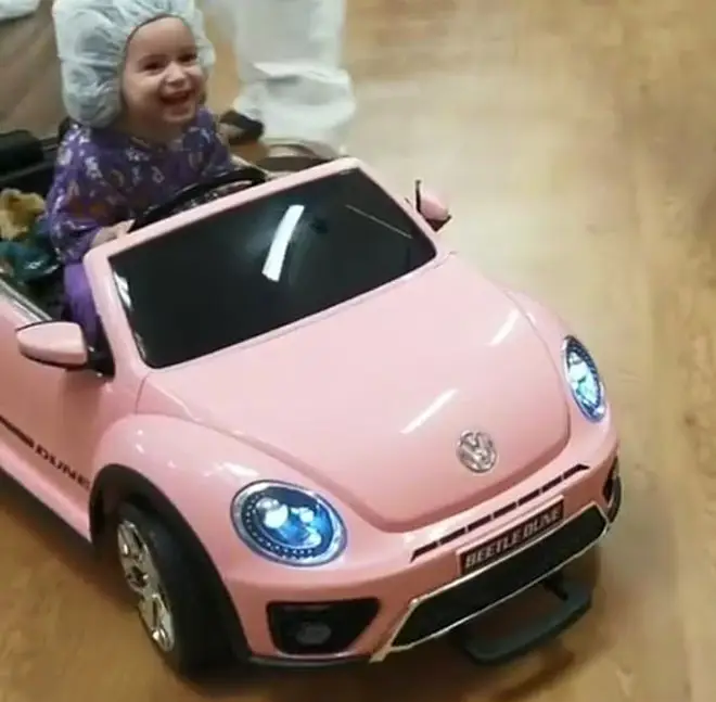 Girl in pink hospital car