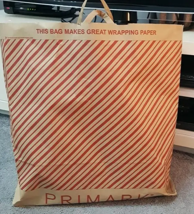 The Primark carrier bags have been decorated with a festive red stripe so they can be cut up and reused as wrapping paper