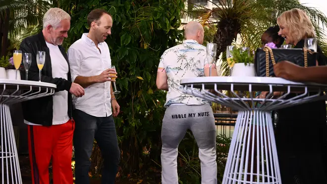 Mike Tindall puts on a pair of underpants that read 'Nibble My Nuts' as Matt Hancock, Chris Moyles, Sue Cleaver and Scarlette Douglas watch
