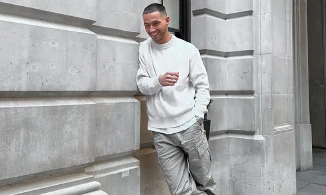 Ron Hall posing in London wearing a cream jumper