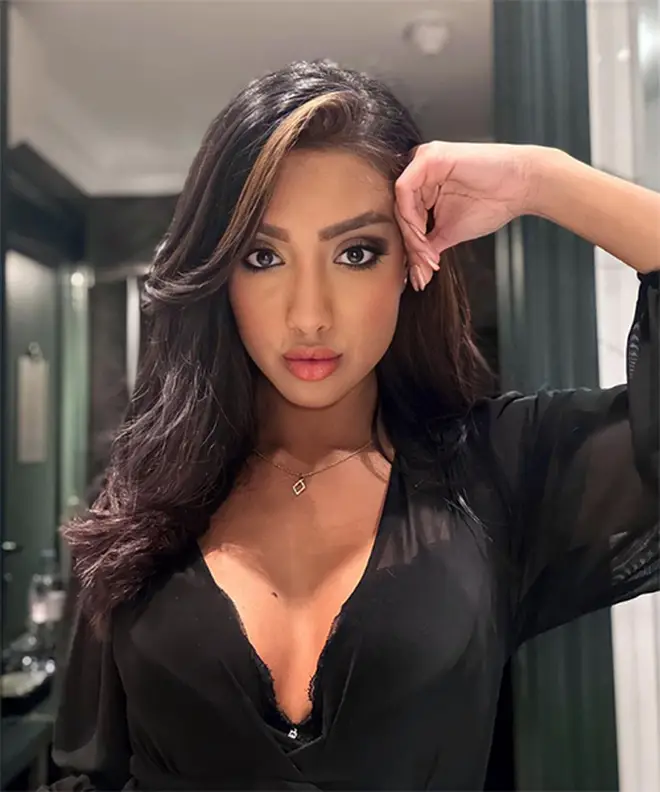 Love Island's Sanam Harrinanan posing in a black top for a bathroom selfie