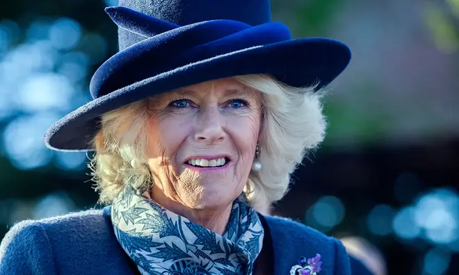 Camilla Parker-Bowles wearing blue hat and scarf and smiling