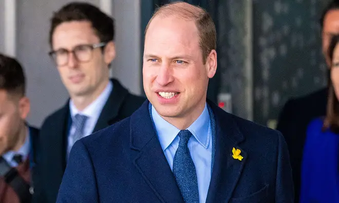 Prince William in blue suit and tie smiling