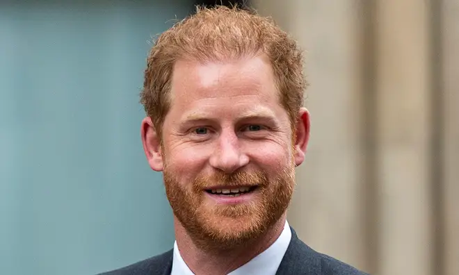 Prince Harry smiling in black suit