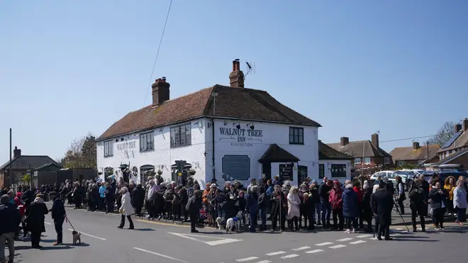 Fans and locals of Paul O'Grady line the streets outside the Walnut Tree Pub in Aldington, Kent, for the funeral procession