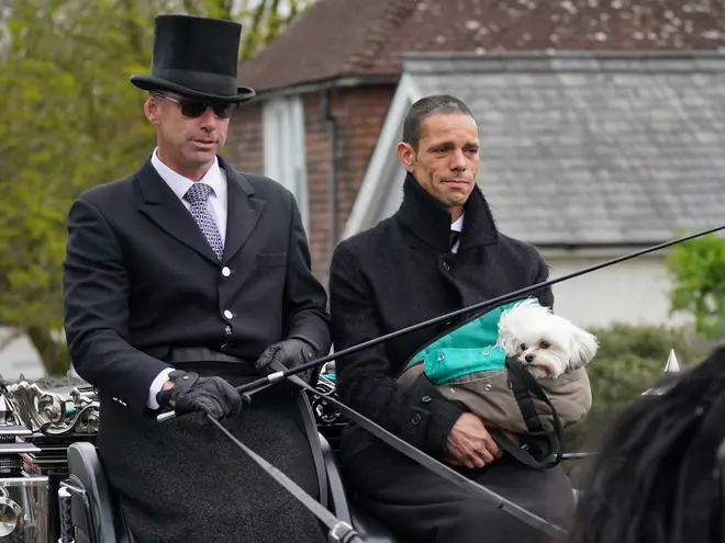 Andre Portasio holds Paul O'Grady's beloved dog Conchita in his arms as he travels through the procession