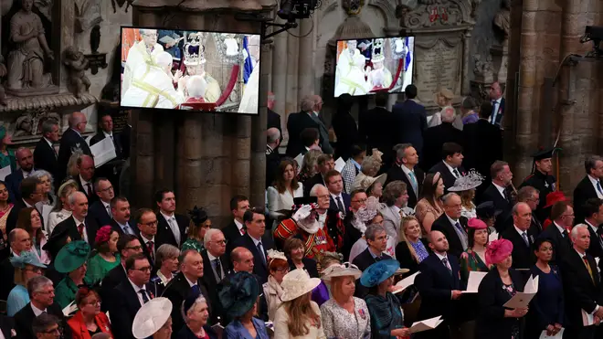 Guests look on as the Archbishop of Canterbury Justin Welby places the St Edward's Crown onto the head of Britain's King Charles III