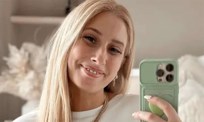 Stacey Solomon with blonde hair smiling for an Instagram selfies with her green phone