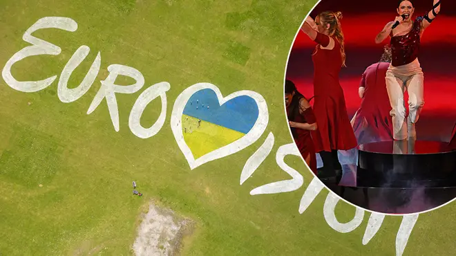 Eurovision spelled out on a green back drop with a picture of Mae Muller performing