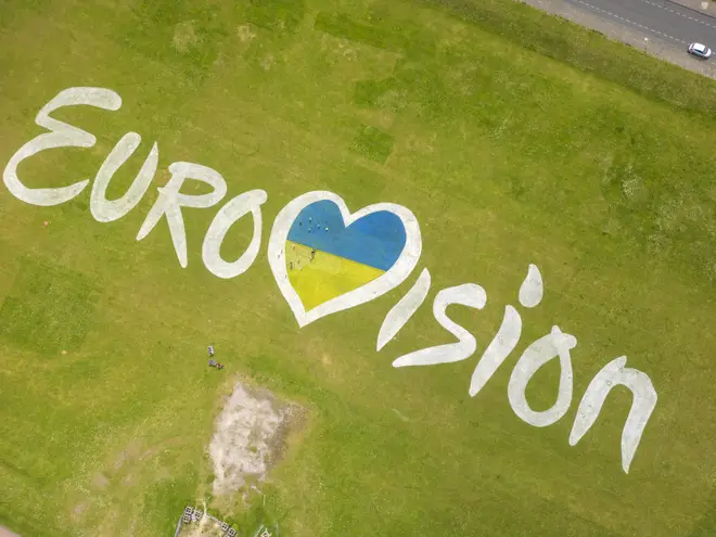 Eurovision sign with a heart instead of a v filled with Ukraine colours