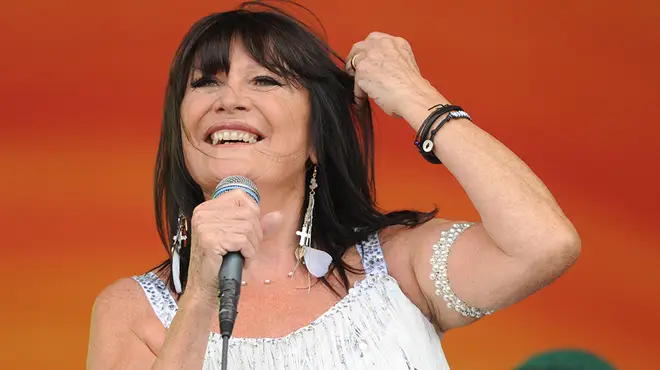 Sandie Shaw performing on stage wearing a white floaty top