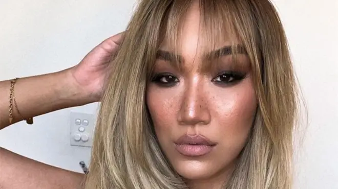MAFS Janelle Han in full glam makeup looking sultry at the camera with blonde hair and fringe