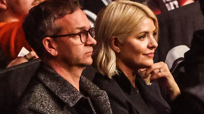 Holly Willoughby and Dan Baldwin watching something at the theatre