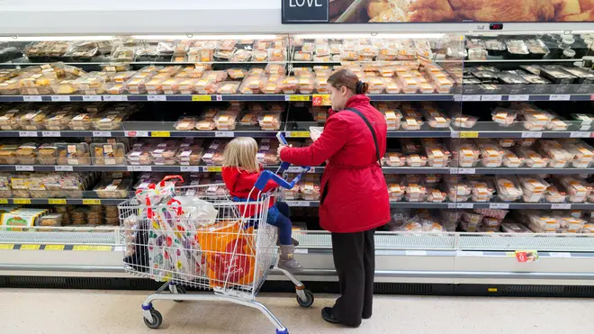 A mother with her child in a shopping trolley shopping in a supermarket, UK