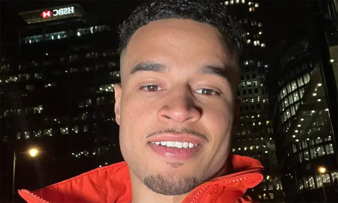 Toby Aromolaran wearing a red jacket while in London at night time