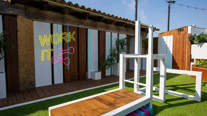 The Love Island villa's graden gym completely with workout bench and 'Work It' neon lights