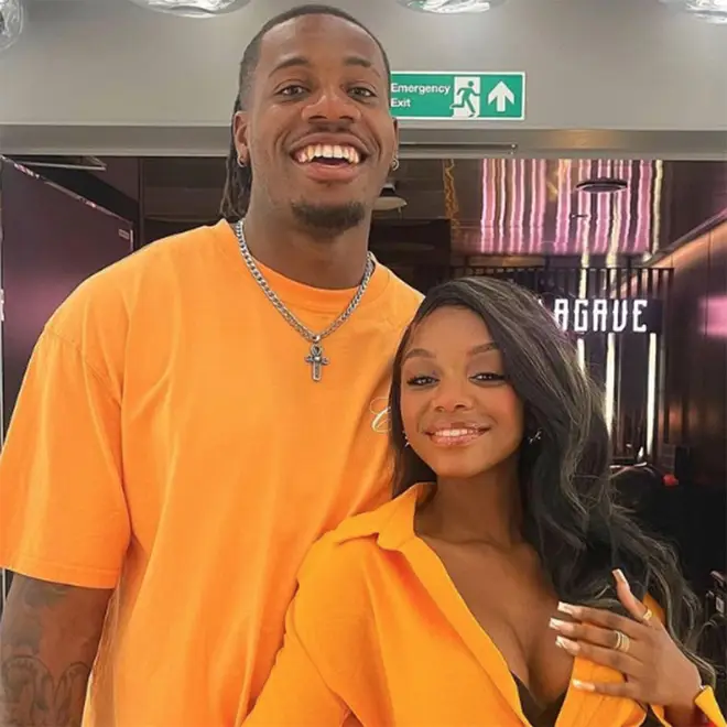 Shaq and Tanya both wear bright orange outfits and pose for a mirror selfie