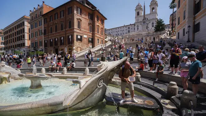 Tourists cool off at Fontana della Barcaccia as Rome experiences soaring temperatures