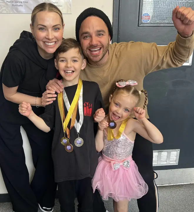 Adam Thomas posing with wife Caroline and their children as they win medals