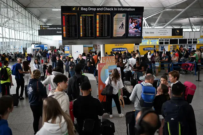 Passengers at Stansted Airport wait to find out if their flights are delayed or cancelled