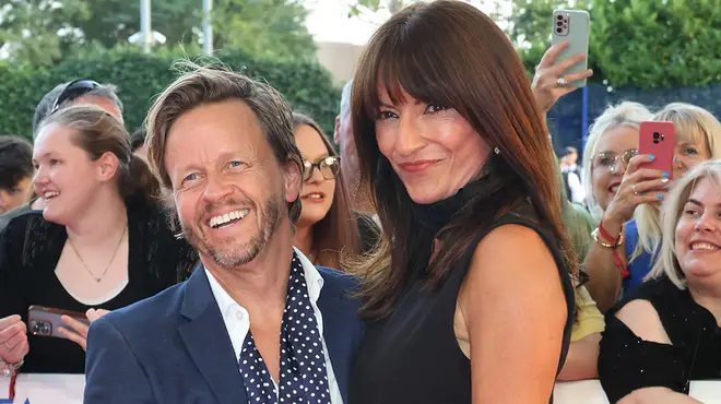 Davina McCall wearing a black dress on the red carpet with boyfriend Michael Douglas