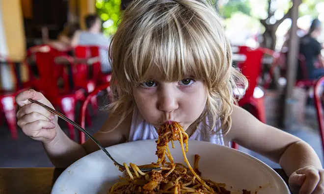 Young child eating spaghetti